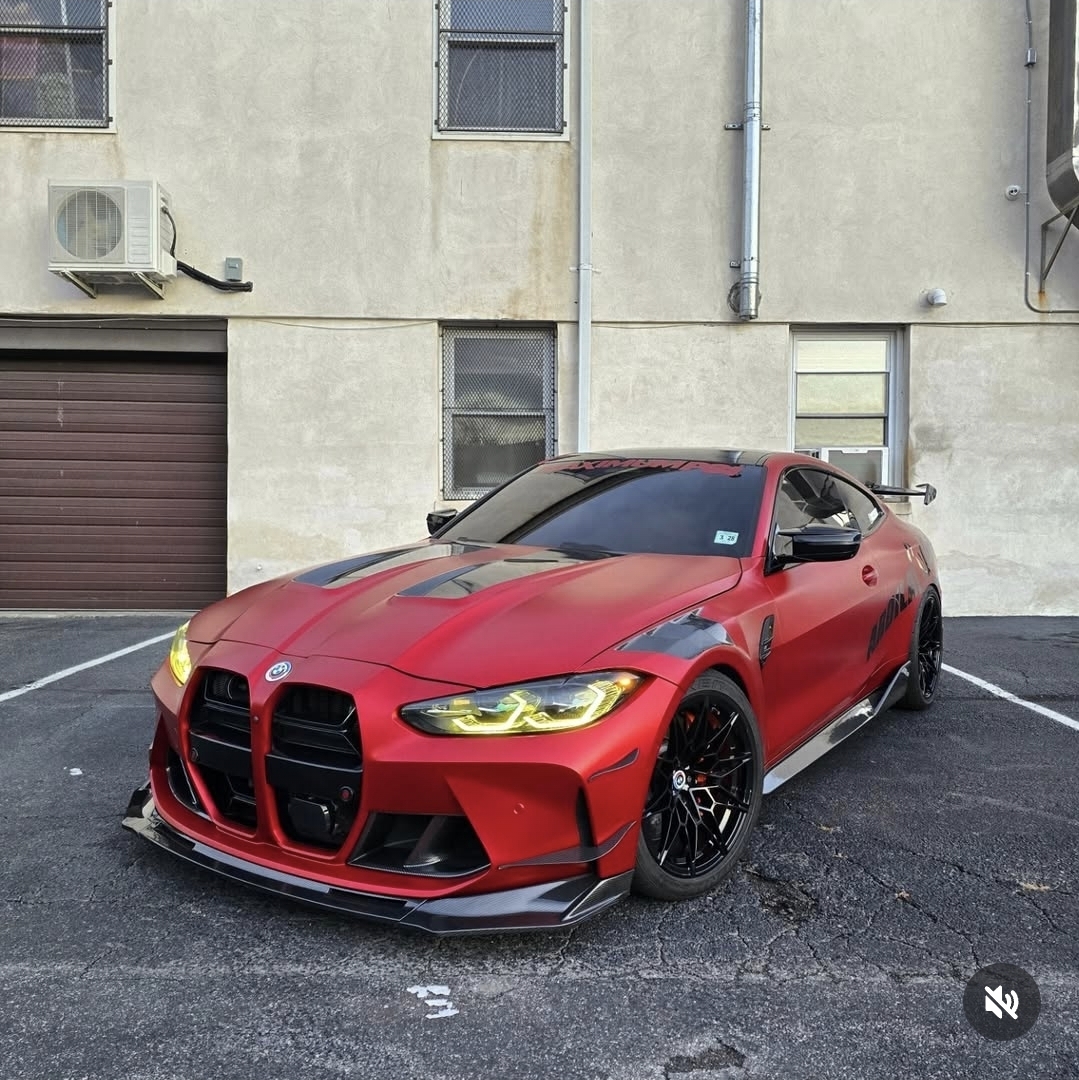 Matte red BMW M4 coupe with widebody kit and yellow daytime running lights wrapped in 3M vinyl