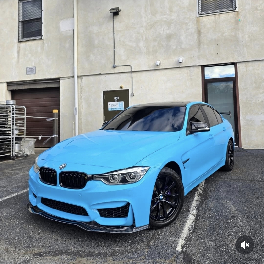 Blue wrapped BMW M3 sedan with black roof, black wheels and rear wing